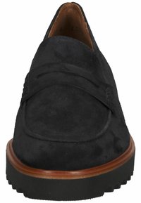 Mocassins en suede noir avec une bande surélevée sur le dessus et une semelle en caoutchouc noir texturé. Doublure intérieure en cuir lisse.
