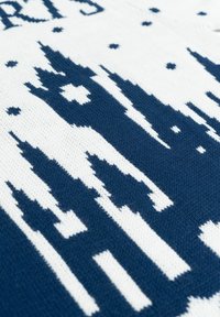 Tessuto lavorato a maglia blu navy e bianco con un design di skyline caratterizzato da alte sagome architettoniche, posto su uno sfondo testurizzato con punti.