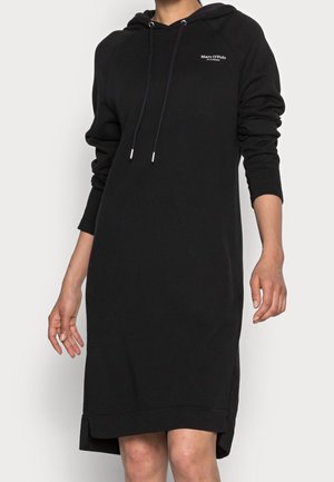Robe à capuche noire à manches longues avec cordons de serrage à l'avant et petit logo blanc Marc O’Polo sur la poitrine gauche, portée par une personne devant un fond uni.