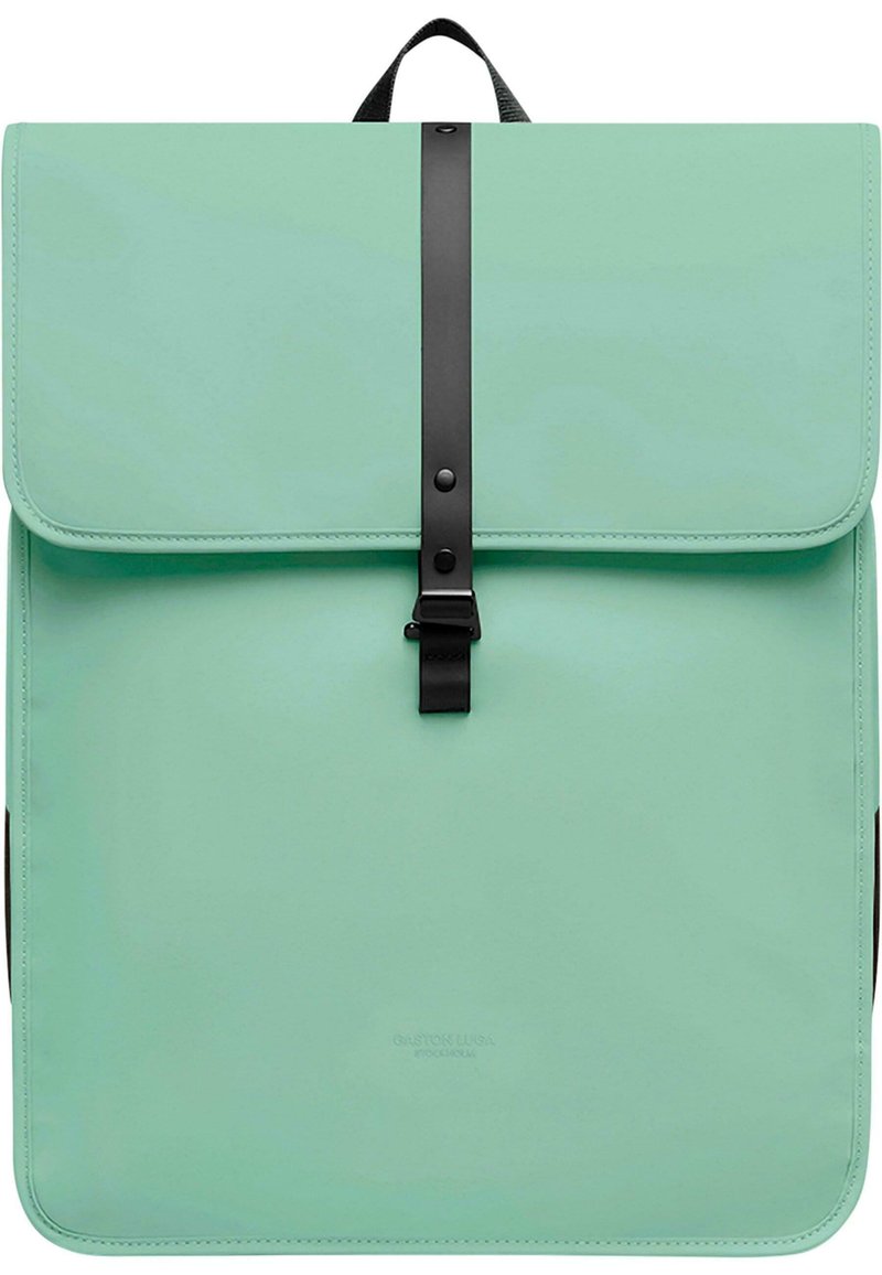 Mintgrønn ryggsekk laget av syntetisk materiale, med klaffelukking som har en svart stropp og spenne, teksturert overflate og avrundede kanter.