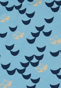 Tessuto azzurro chiaro con un motivo ripetuto di mezze lune blu scuro e forme di barchette di carta beige, creando un design giocoso.