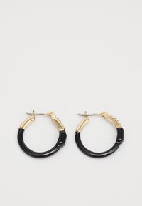Boucles d'oreilles en forme de créole avec un design segmenté en or et noir, présentant une partie inférieure lisse et courbée et une partie supérieure texturée.