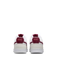 White Nike sneakers with maroon accents and a textured, suede heel. Features a padded collar and a rubber sole with a minimal design.