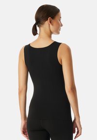 Black sleeveless top with a round neckline, fitted design, and smooth texture. Fabric appears stretchy and lightweight, offering a minimalist look.