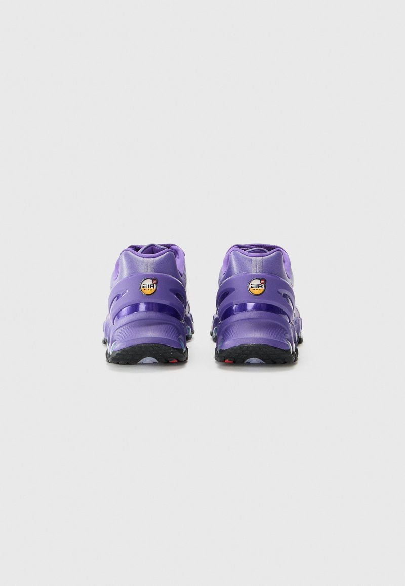 Lila Sportschuhe mit einer glatten synthetischen Oberseite, geschichtetem Design, schwarzer strukturiertem Außensohle und kreisförmigen Logo-Akzenten an der Ferse.