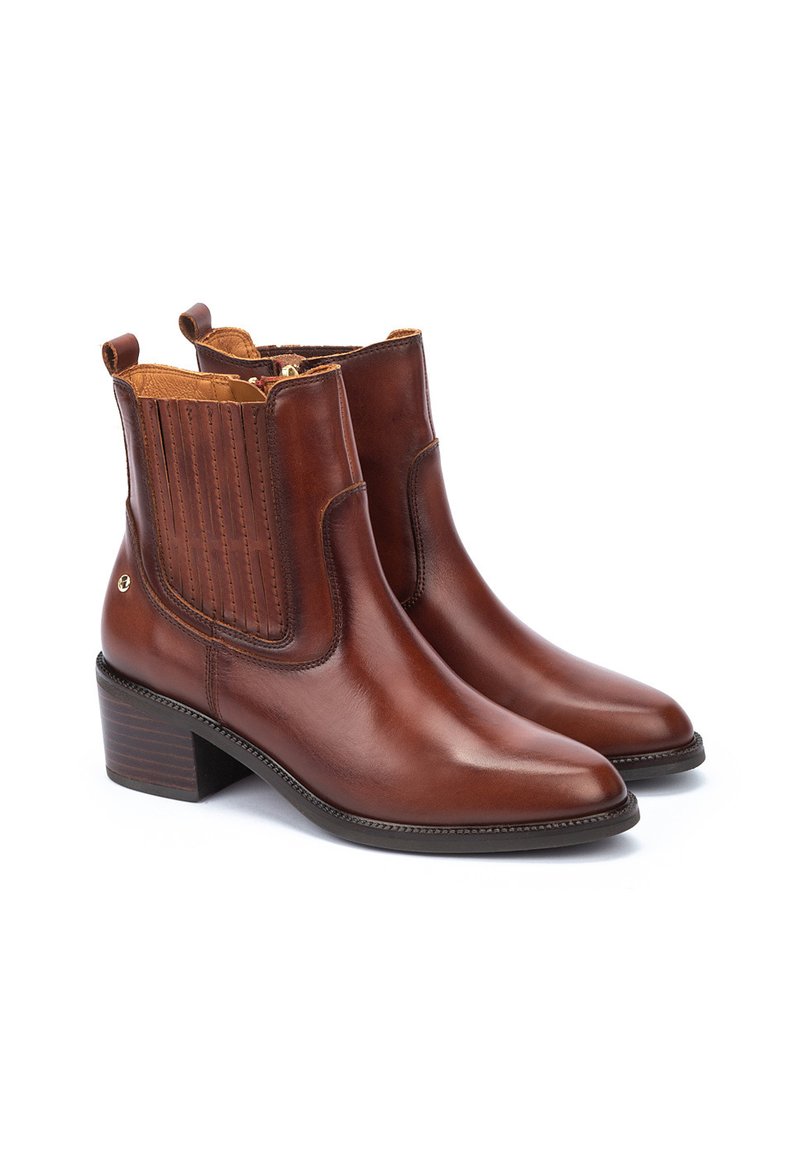 Botas de tobillo de cuero marrón con punta afilada, paneles laterales elásticos y tacón apilado. Presenta un diseño cosido y cierre con cremallera.
