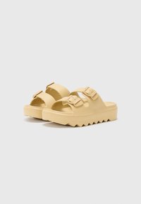 Yellow rubber sandals with two adjustable straps, zigzag sole, and smooth texture. Designed for comfort and casual wear.