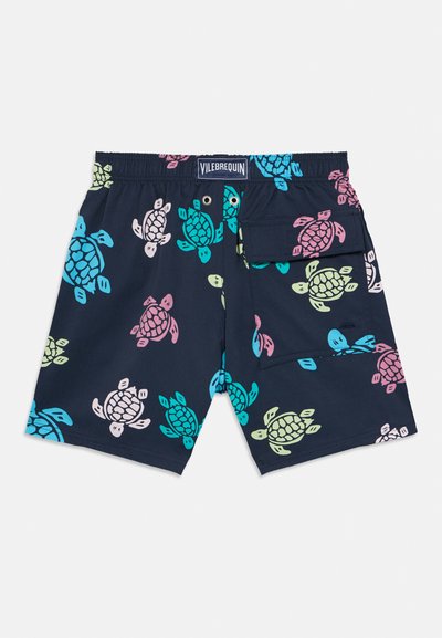 Tmavomodré plavkové šortky s farebnými potlačami morských korytnačiek, elastickým pásom, kovovými očkami a klopovým vreckom na pravej strane.