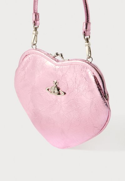 Ružová metalická taška v tvare srdca s prasknutou textúrou, striebornými kovaniami a malým dekoratívnym príveskom v tvare planéty na prednej strane.