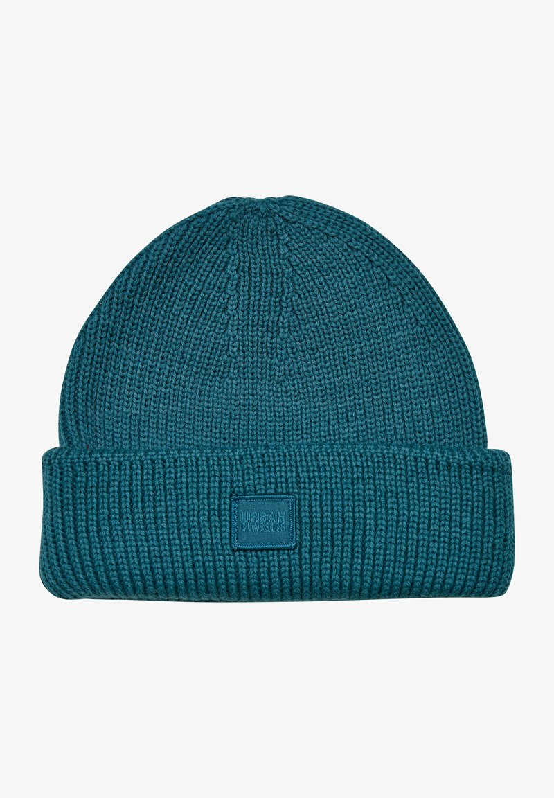 Teal knit beanie with a ribbed texture and a folded cuff. Features a square patch labeled "URBAN CLASSICS" in a contrasting color.