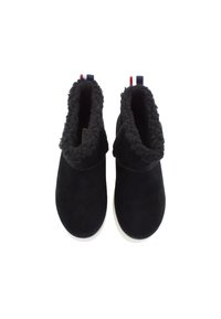 Ein Paar schwarze Wildleder-Mokassins mit gemütlichem Fleece-Futter und weißen Sohlen, von oben auf einem weißen Hintergrund gezeigt.