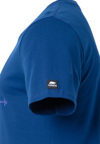 Camiseta de algodón azul con mangas cortas, que presenta una etiqueta cosida en la manga izquierda. La tela es suave, con un brillo sutil.