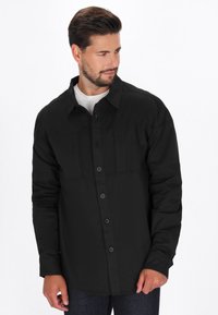 Camicia nera a maniche lunghe con bottoni, realizzata in misto cotone, con due tasche sul petto e colletto classico. Tessuto liscio e taglio dritto.