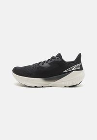 Chaussure de course pour homme en mesh noir avec une surface texturée, une semelle superposée blanche et grise, et un motif de traction en caoutchouc bien visible.
