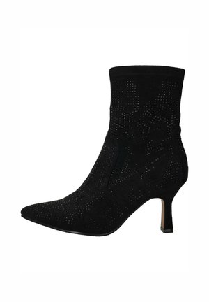 Zwarte enkellaars van zacht suede met geperforeerde details, puntige neus en een slanke hak. Voorzien van een aansluitende bovenkant voor een strakke silhouet.