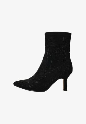 Zwarte enkellaars van zacht suede met geperforeerde details, puntige neus en een slanke hak. Voorzien van een aansluitende bovenkant voor een strakke silhouet.