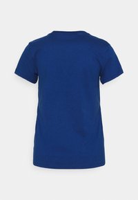T-shirt bleu uni à manches courtes montré de dos sur un fond neutre.