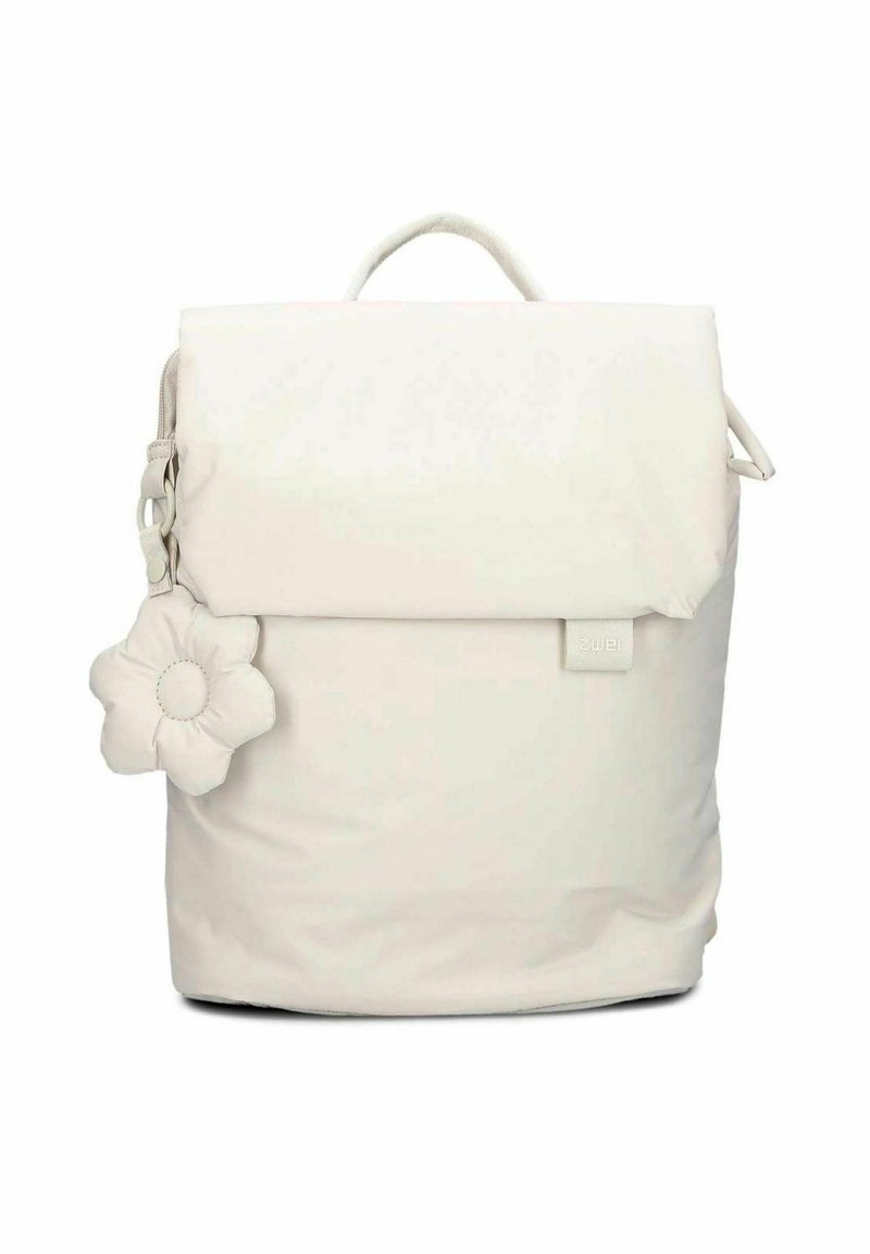 Sac à dos blanc avec un rabat repliable, fabriqué en matériau doux. Présente un charm en forme de fleur texturé et une étiquette de marque discrète.