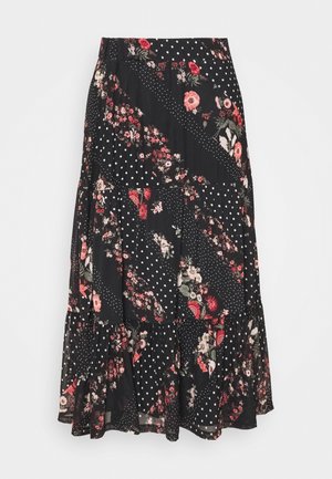 Sort midinederdel nederdel med lagdelt design, der har blandede blomster- og hvide polkaprikker i diagonalt lapperarbejde.
