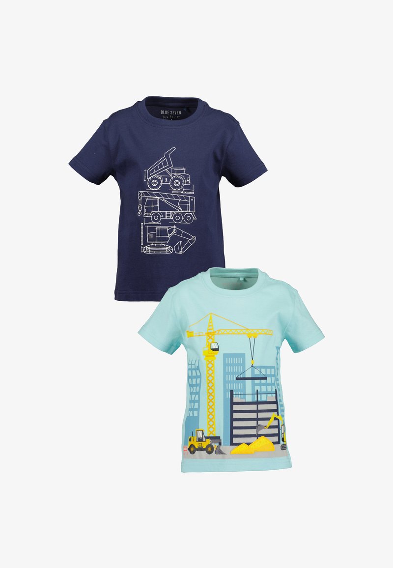 Deux t-shirts pour enfants : un bleu marine avec un plan blanc de camions de construction, et un bleu clair avec un imprimé coloré de chantier et de machinerie.