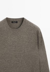 Grijze gebreide trui met een ronde hals, met een zachte textuur en minimalistisch ontwerp. Het label zegt "Massimo Dutti."