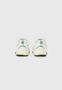 Zapatillas deportivas con parte superior de malla blanca, acentos en color azul verdoso y suelas de goma negra. Incluyen un cuello acolchado y un diseño trasero estructurado.