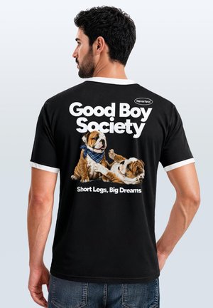 Man wearing black t-shirt with white trim, showing back text "Good Boy Society" and two playing bulldogs with "Short Legs, Big Dreams."
