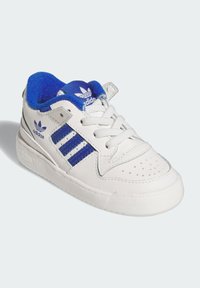 White leather sneaker with blue accents, featuring three blue stripes, perforated toe, and blue textile lining. Rubber sole with grip.