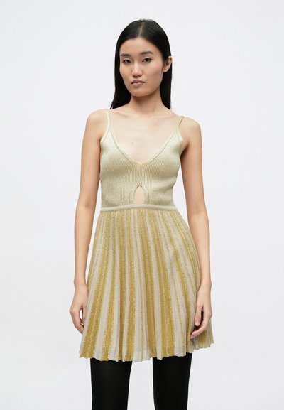 Metalické zlaté a krémové plisované šaty s výstrihom do V a otvorom v tvare kľúčovej dierky, s tenkými ramienkami a rozšírenou sukňou.