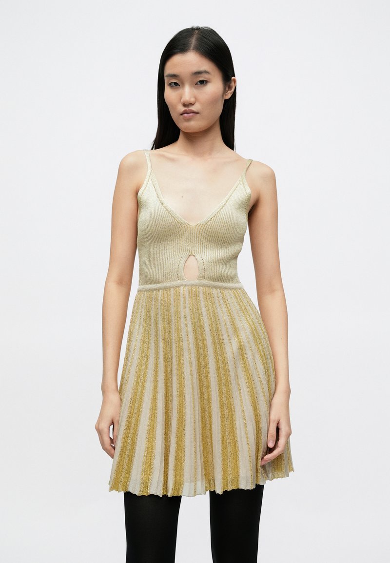 Plissiertes Kleid in metallischem Gold und Creme mit V-Ausschnitt und Schlüsselloch-Detail, dünnen Trägern und ausgestelltem Rockdesign.