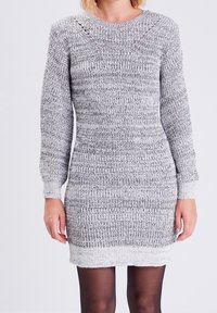 Robe tricotée gris et blanc avec manches longues, col rond et poignets côtelés. Présente des rayures horizontales et un motif en tricot ajouré sur les épaules.