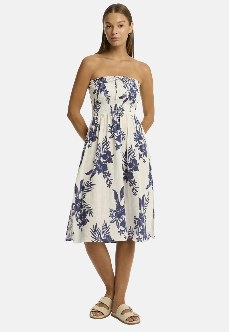 Abito midi senza spalline in cotone crema con motivo floreale blu. Presenta un corpetto arricciato e una gonna svasata. Abbinato a sandali beige.
