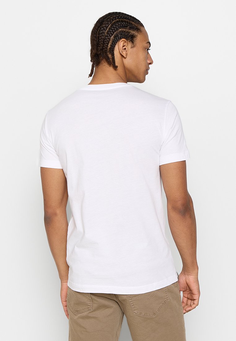 Camiseta de algodón blanca con mangas cortas, cuello redondo y un diseño liso. La vista trasera muestra una textura suave y una forma ajustada.