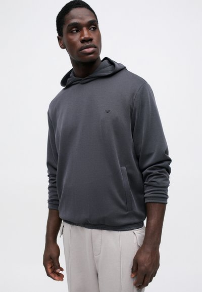 Mørkegrå stripete hettegenser med frontlomme og snorer i hetten. Mykt stoff med avslappet passform og ribbede mansjetter. Minimalistisk logodetalj.