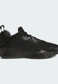 Zapatillas deportivas negras con una parte superior de punto texturizado, cierre de cordones y cuello acolchado; cuentan con una suela gruesa y negra sólida con un diseño curvado.