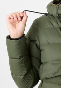 Green puffer jacket with quilted texture, featuring a high collar and adjustable drawstring. The cuff has a black elastic band.
