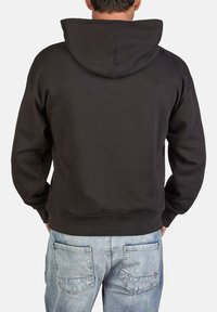Czarna bluza z kapturem o luźnym kroju, z prążkowanymi mankietami i dołem. Tył ma środkowy szew i miękką, teksturowaną tkaninę.