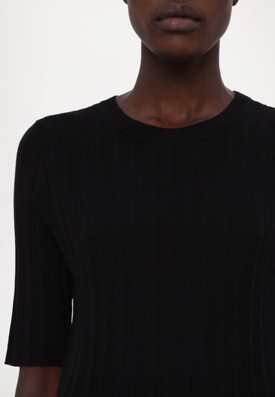 Top negru din tricot cu nervuri, cu mâneci scurte, decolteu rotund și o siluetă adaptată. Textură netedă cu dungi verticale.