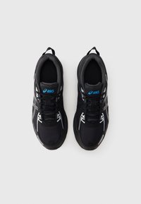 Čierne atletické topánky z sieťoviny a syntetického materiálu s bielymi doplnkami, okrúhla špička a ploché šnúrky. Logo na jazyku v modrej farbe.