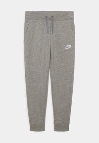 Gray sweatpants with an elastic waistband, drawstring, side pockets, and a white Nike logo on the left thigh. Soft material and tapered fit.