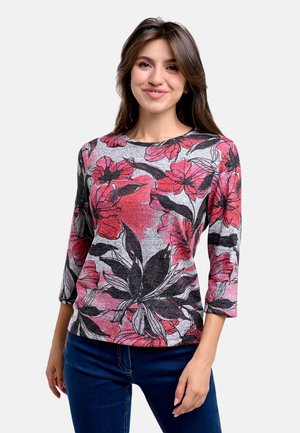 Bluse mit floralem Muster, die rote und schwarze Blumen auf grauem Hintergrund zeigt, runder Ausschnitt, dreiviertel Ärmel und eine weich angenehme Textur hat.