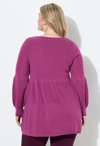 Dlouhý rukáv, ribovaný pletený top v živé magentové barvě, s rozšířeným pasem a vykrojeným výstřihem, s texturovaným povrchem.