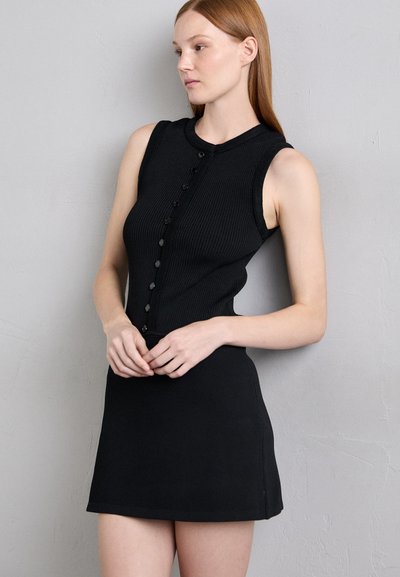 Rochie neagră fără mâneci, din tricot, cu un corset ajustat, textură striată și un dezgolit în față cu nasturi. Fusta are o croială dreaptă și o ușoară evazare.