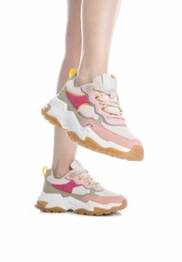 Zapatillas multicolor con materiales de malla y gamuza, forma redondeada, detalles en rosa, gris y amarillo, con una suela de goma gruesa.