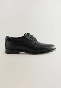 Chaussure de costume noire en cuir, à bout arrondi, avec lacets, détail de surpiqûres sur les côtés et un talon bas. Texture lisse et design classique.
