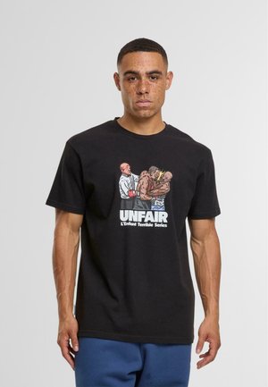 T-shirt nera in cotone con stampa grafica che presenta la parola "UNFAIR" e figure illustrate in una scena di boxe. Maniche corte, collo rotondo.