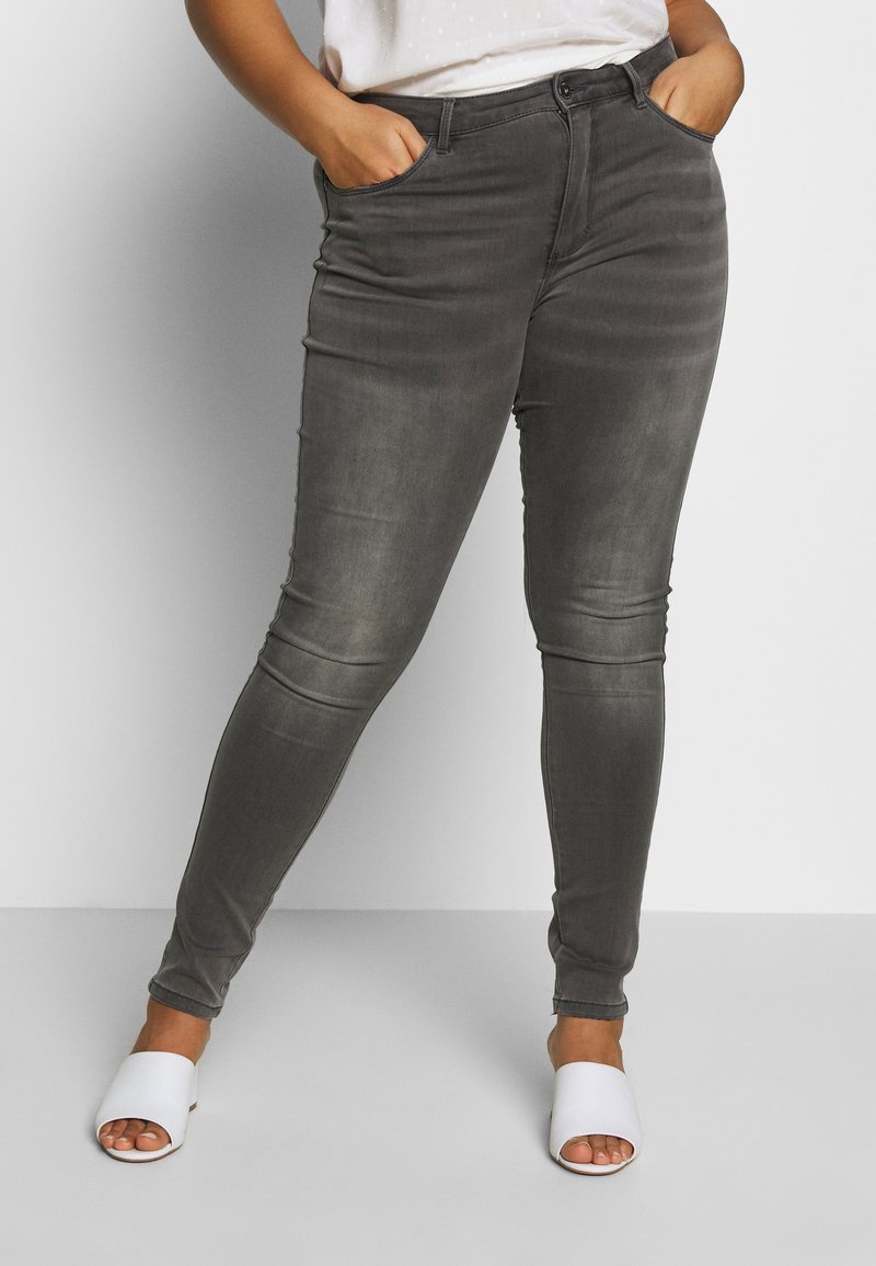 Gray slim-fit jeans with a smooth texture, five-pocket design, and subtle fading. Paired with white open-toe sandals.