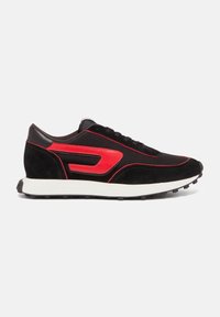 Chaussure de sport en suède noir avec des accents rouges, une tige en mesh texturé et une semelle intermédiaire blanche. Dispose d'une semelle extérieure en caoutchouc avec des crampons pour la traction.