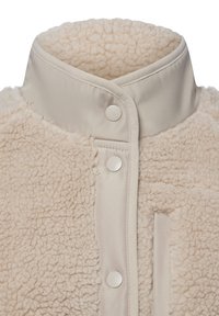Beige fleece jas met een zachte textuur, voorzien van een hoge kraag, drukknoopsluiting en een contrasterend paneel van gladde stof.