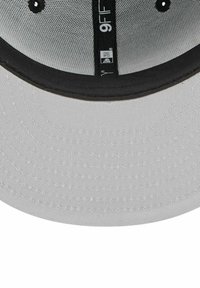 Gray cap with a black visor and textured fabric. Features embroidered detailing and ventilation holes along the top. 9FIFTY label included.